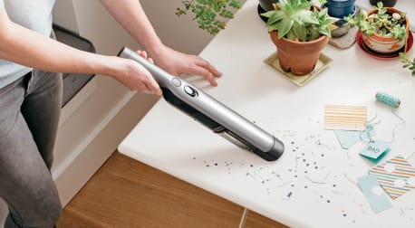 Shark handheld vacuum being used to pick up confetti.